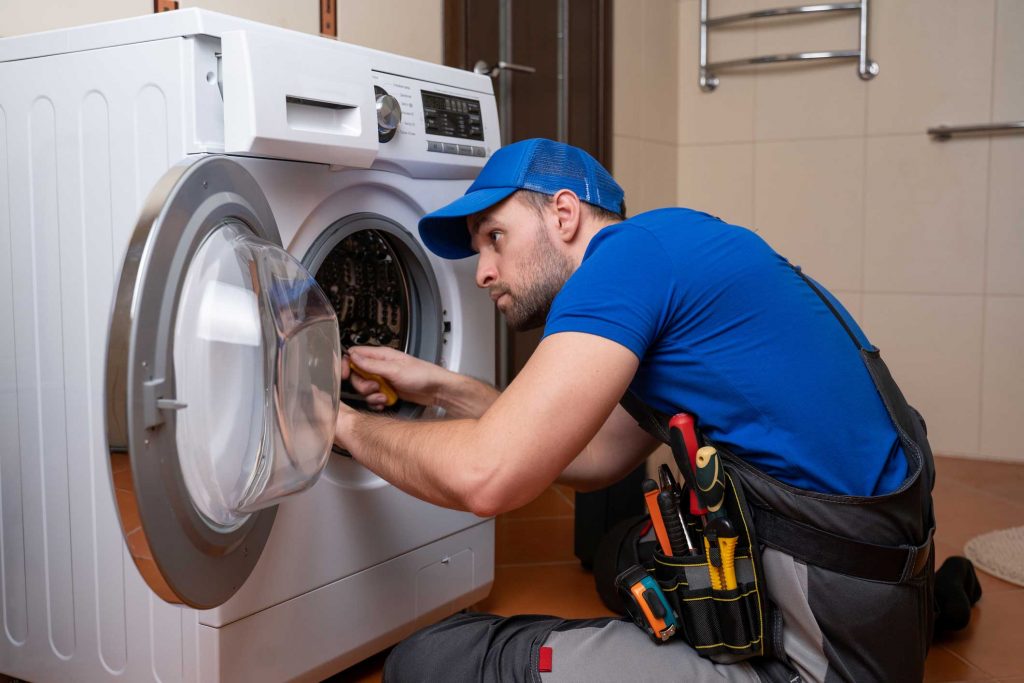 a technician repairing a washer and dryer repair raleigh